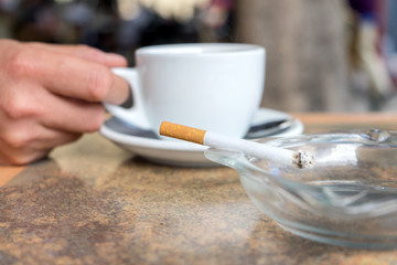 someone enjoy coffee and a cigarette