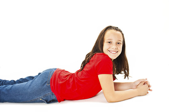 Beautiful young girl in jeans lying on the floor. Isolated on white background