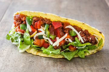 Traditional Mexican tacos with meat and vegetables on wooden background
