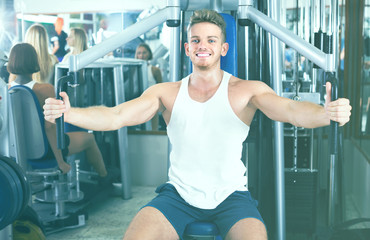 Fototapeta na wymiar Young man using fly machine in gym.