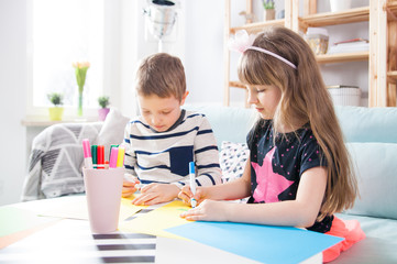 Fototapeta premium Brother and sister drawing with colorful pencils at home