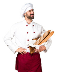 Young baker holding some bread and winking