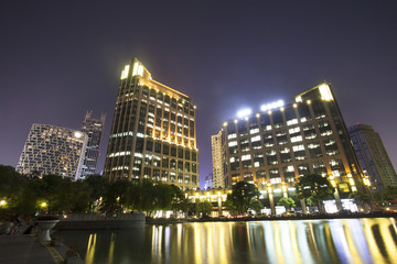 Fototapeta na wymiar modern buildings near river at night