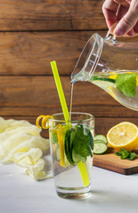 Homemade lemon lemonade with cucumber and mint on the rustic background