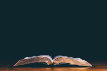 Bible open on black background