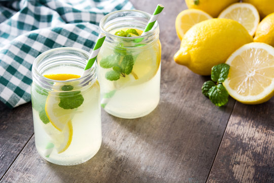 Lemonade drink in a jar glass on wooden background. Copyspace.
