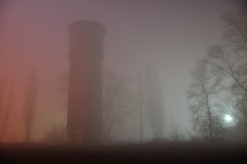 Naklejka na ściany i meble Water Tower at night in the fog
