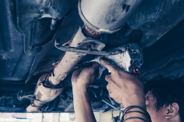 car service, repair, maintenance concept - auto mechanic man working at workshop