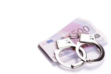 Pair of handcuffs closeup on euro banknotes stack