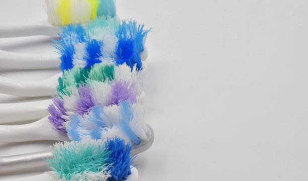 Worn colorful toothbrushes with copy space and white background