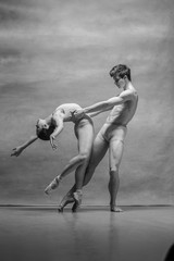 Obraz na płótnie Canvas Couple of ballet dancers posing over gray background