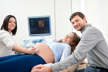 Parents expecting of child and diagnosing with ultrasound.