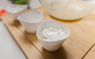 Cheese In Bowl On Cutting Board At Kitchen