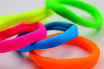 Fototapeta premium Some fluorescent elastics on white background. Tilt-shift effect applied.