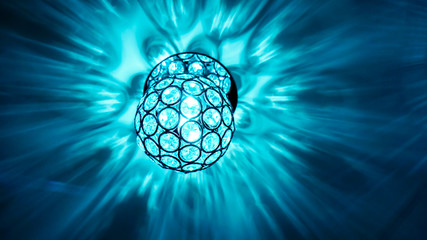 bright lighting ball with circle patern hanging from the ceiling on the ivory ceiling with light reflection