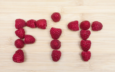 Fit Text Made Of Raspberries On Table