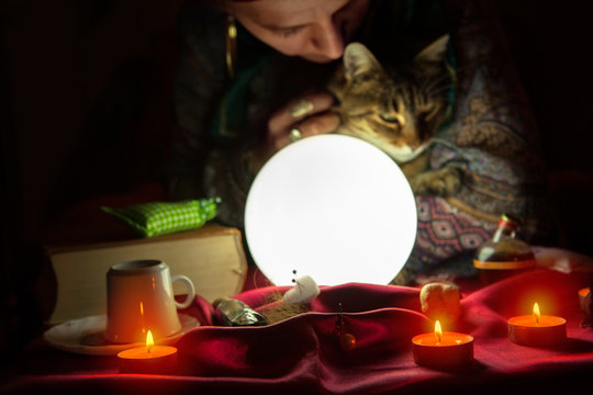 Fortuneteller during session with crystal ball and cat