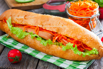 Hot dog with sausage, carrots and sauce, selective focus