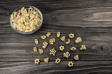 Raw macaroni on an old wooden table. Mix pasta