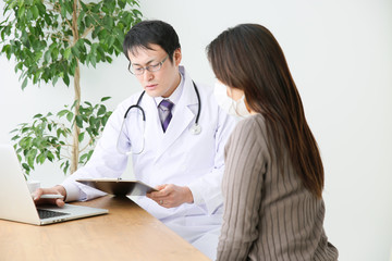 診察室で診療する医師と患者