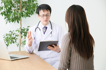 診察室で診療する医師と患者
