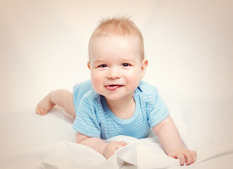 Fototapeta premium Eight month old baby lying in the bed on white sheet