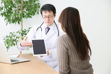 タブレットで説明する医師と患者