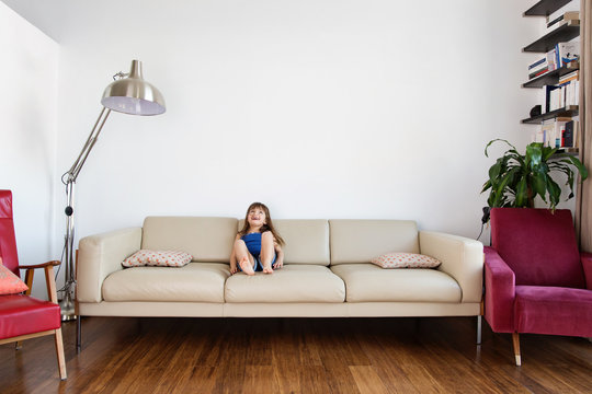 little girl laughing on the couch in the living room