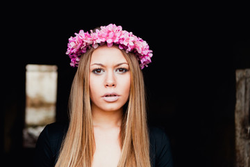 Beautiful portrait of a blonde girl with a pink crown of flowers