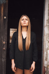 Obraz na płótnie Canvas Sensual blonde girl in black shirt waiting near a door