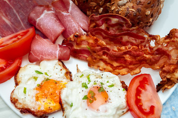 Breakfast eggs with crispy bacon and ham