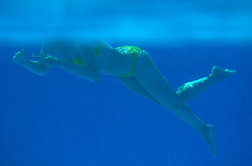 Woman swimming underwater in the swimming pool.