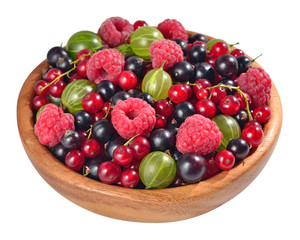 Various kinds of fresh berries in a wooden bowl on a white