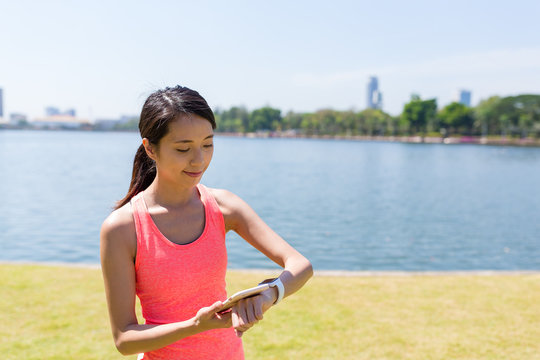 Young Woman connecting cellphone and smart watch