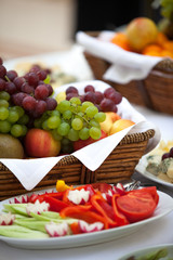 Basket of fresh organic fruits from grapes and apples on the table. I