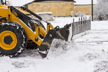 tractor loader cleans snow after a snowfall
