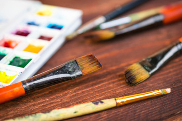Fototapeta premium Paints and brushes on wooden table
