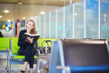 Fototapeta na wymiar Woman in international airport terminal, reading book