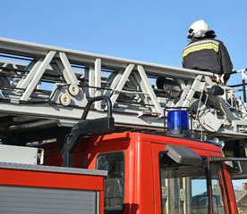 Firefighter works on the top of a fire truck