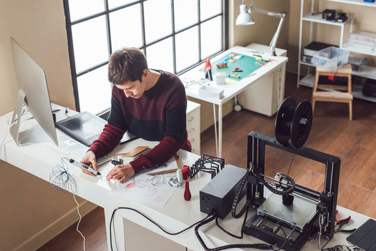 Graphic designer using 3d printing pen at his studio.