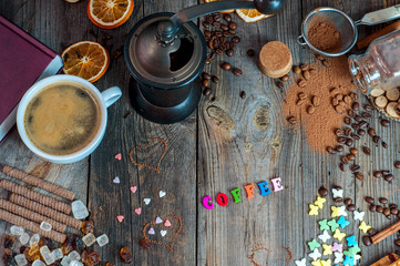 Fototapeta na wymiar cup of black coffee with sweets and spices on a gray wooden surface
