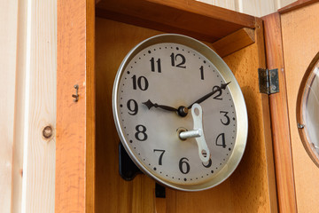 Fototapeta na wymiar Mechanical clock in a wooden case. The key for the clock.