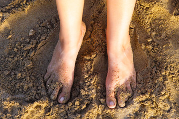 Woman feet standing on sand