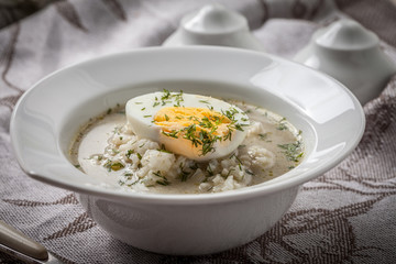Sorrel soup with egg in white bowl.