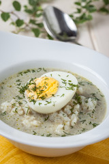 Sorrel soup with egg in white bowl.