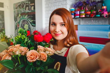 young girl working in a flower shop, Floristry makes selfie photo with a bouquet of flowers