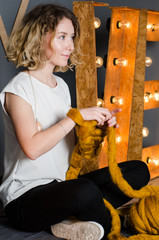 Young woman sitting and holding merino wool near LOVE sign