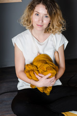 Young woman sitting and holding merino wool near LOVE sign