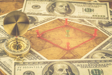 Compass with money on map