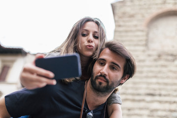 Loving young couple hugging take selfie in the historic city center of Florence, Tuscany